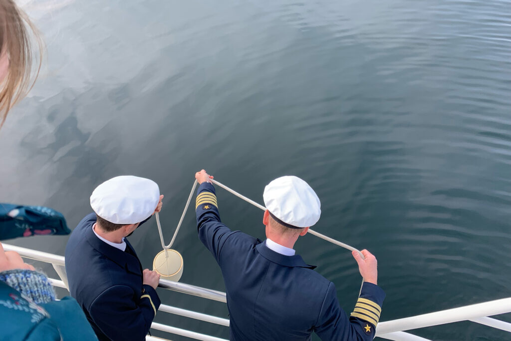 Urne wird bei einer Seebestattung ins Meer hinabgelassen.